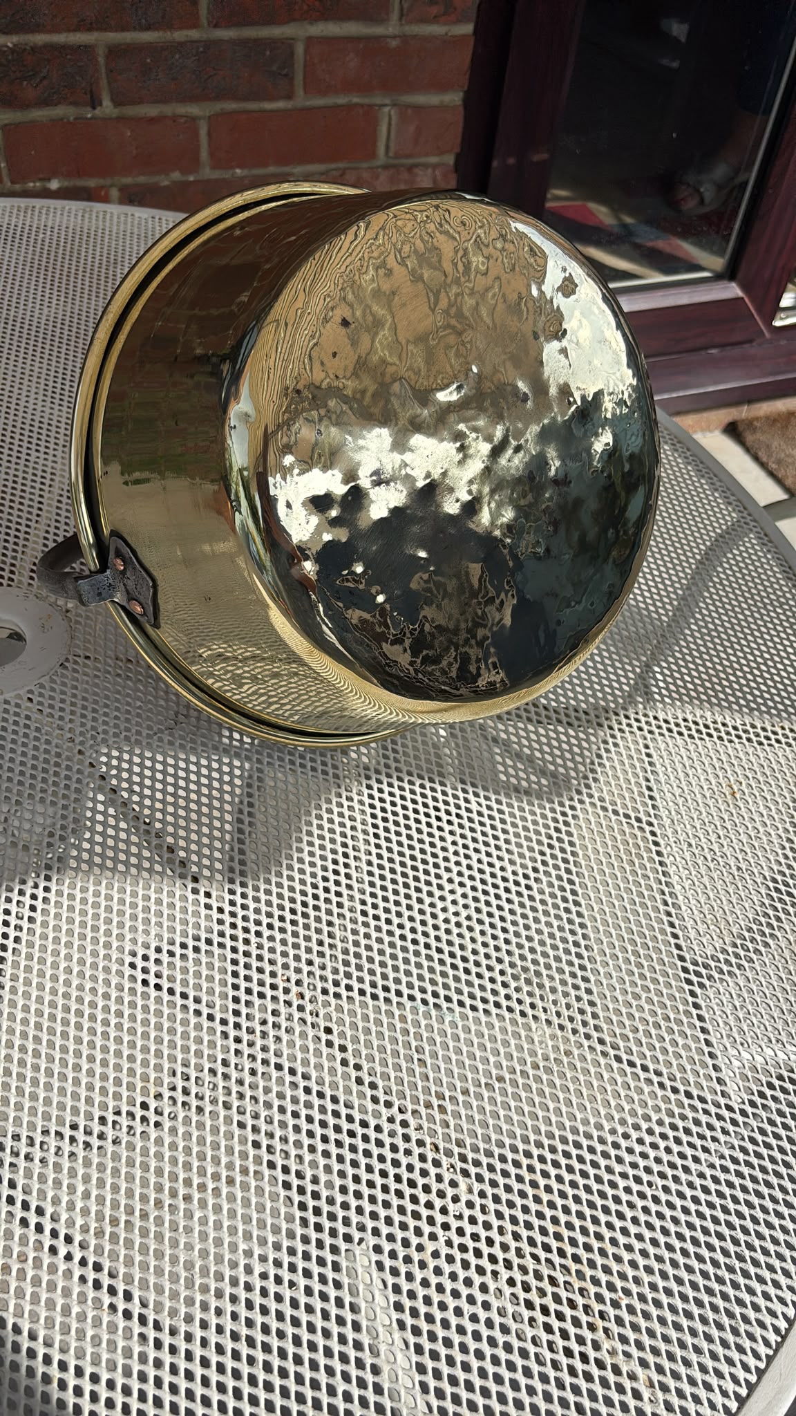 Image of the base of A solid vintage brass preserving pan with fixed iron handle