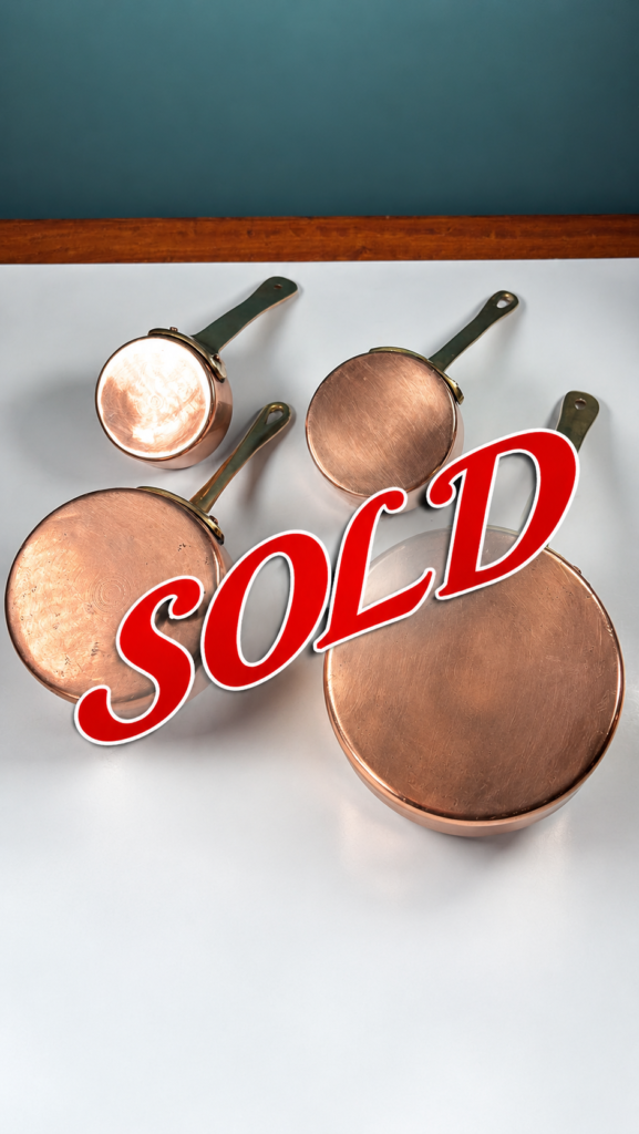 An image of A SOLD set of 4 graduated copper mini saucepans with brass handles