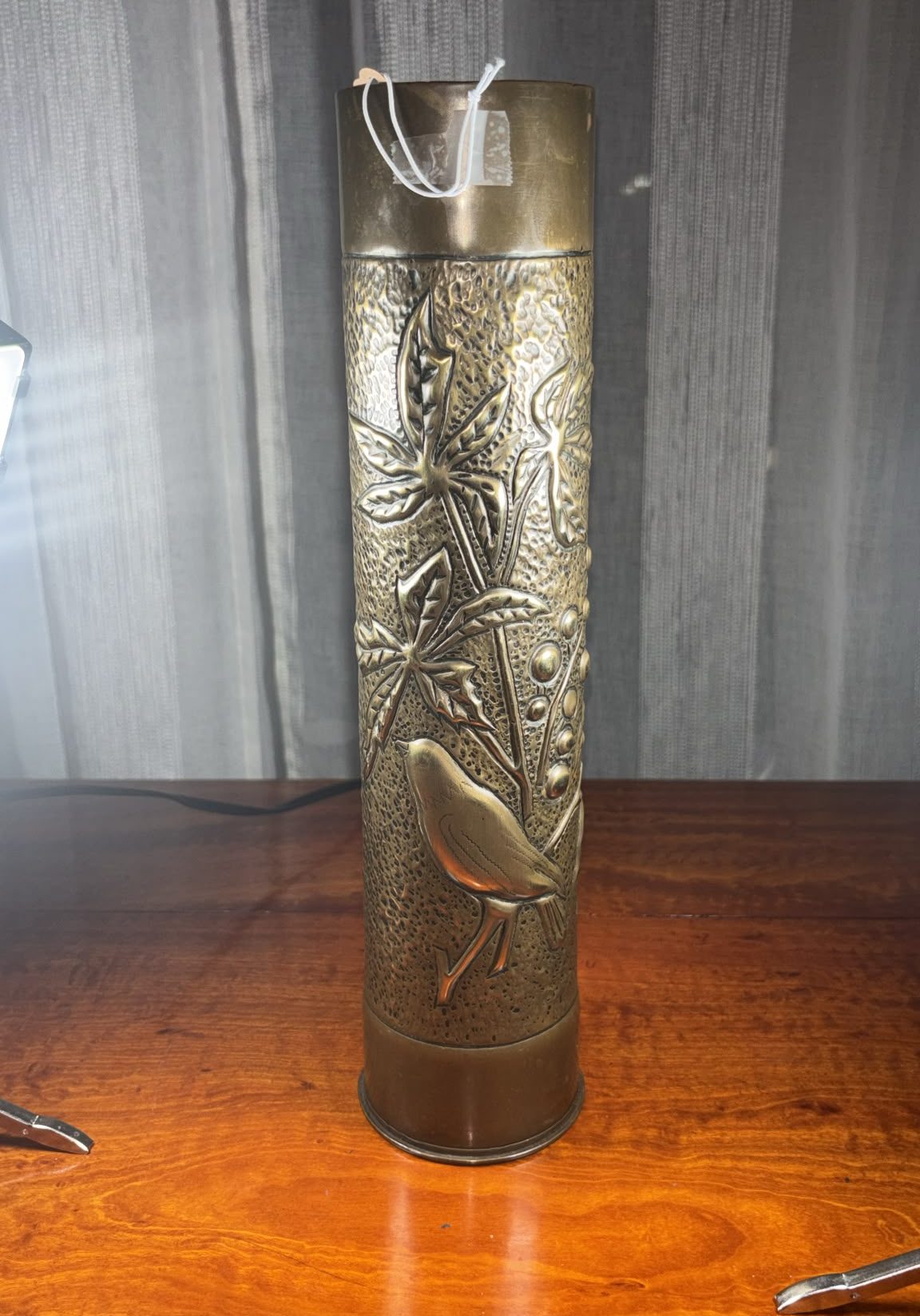 Image of tall brass vase from 1915 with heavy relief embossing